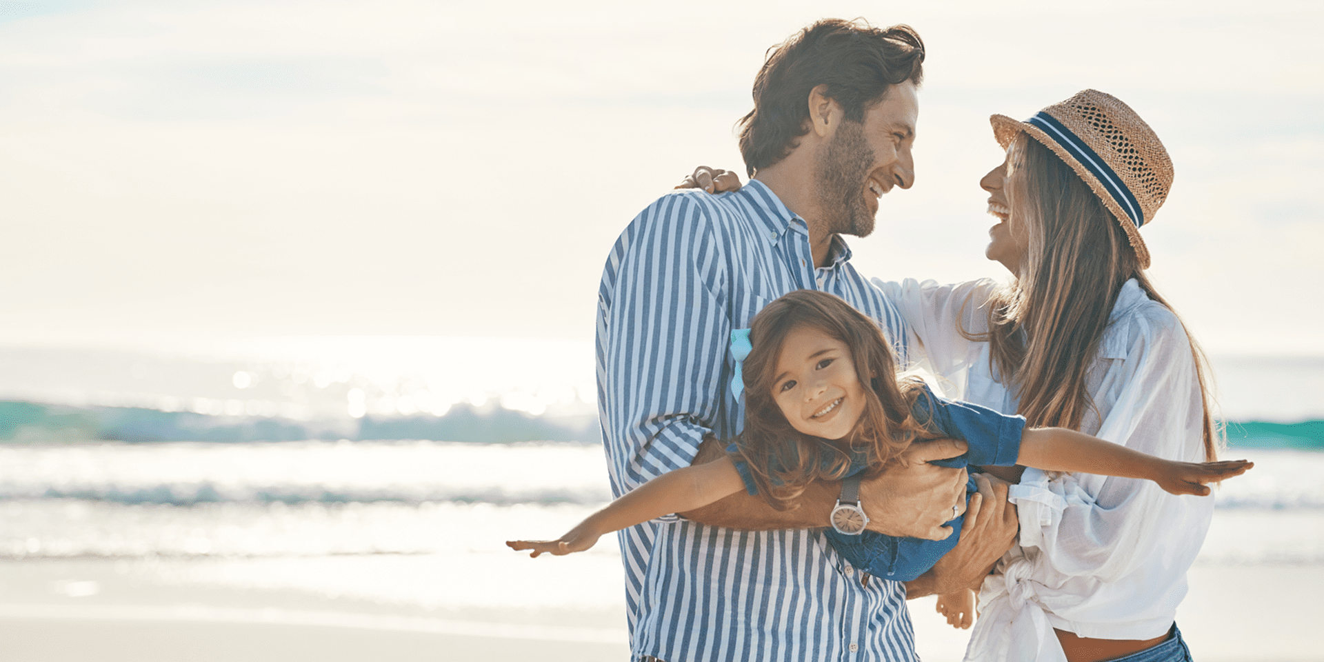 Parents with child on sunny beach